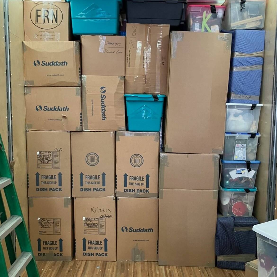 Cardboard moving boxes and protective cushioning over items neatly stacked and secured inside a moving truck.